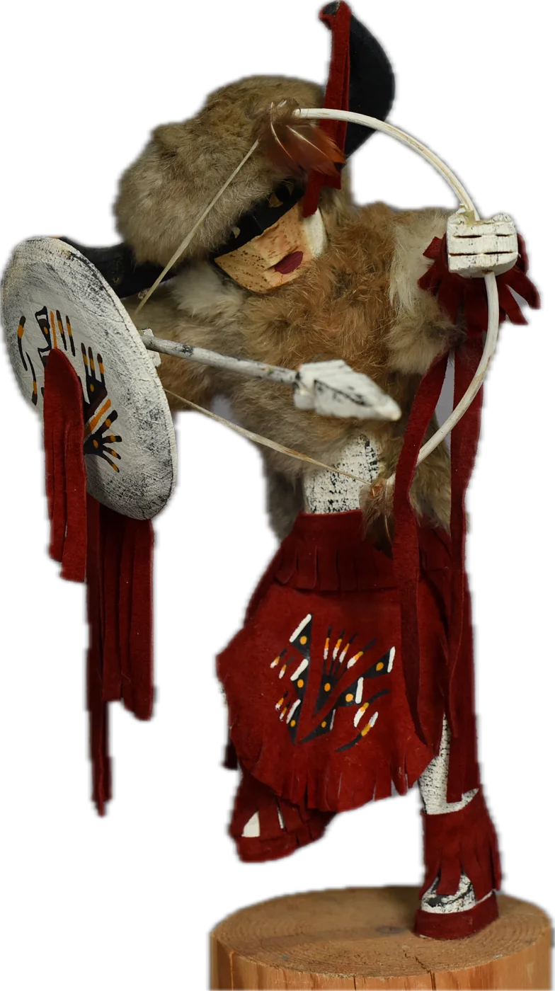 The kachina figure of Quauhtemoczin — fur headdress, painted shield held forward, red streamers