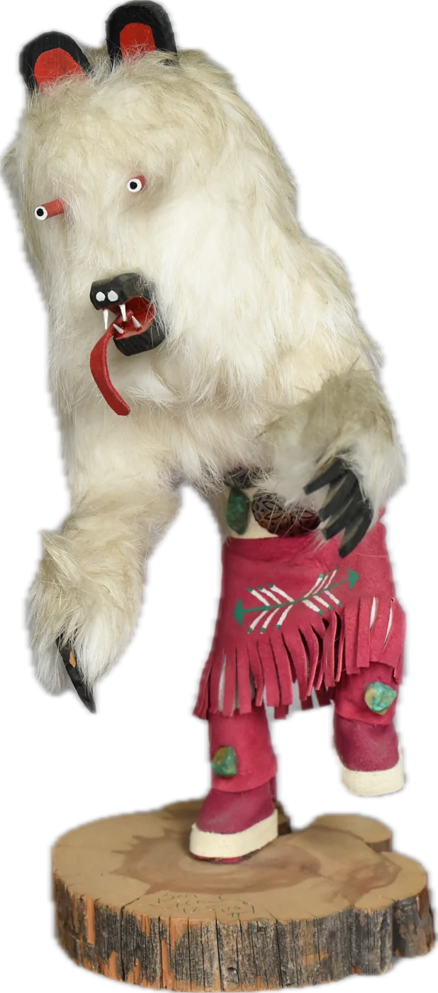 The kachina figure of Tzolquixtli — white fur, black-tipped ears, red tongue, caught mid-dance